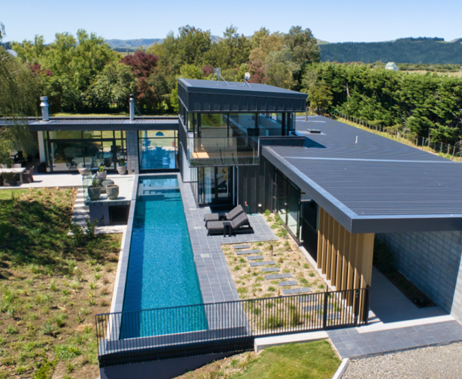 Pool fencing requirements shown around a long lap pool beside a modern home